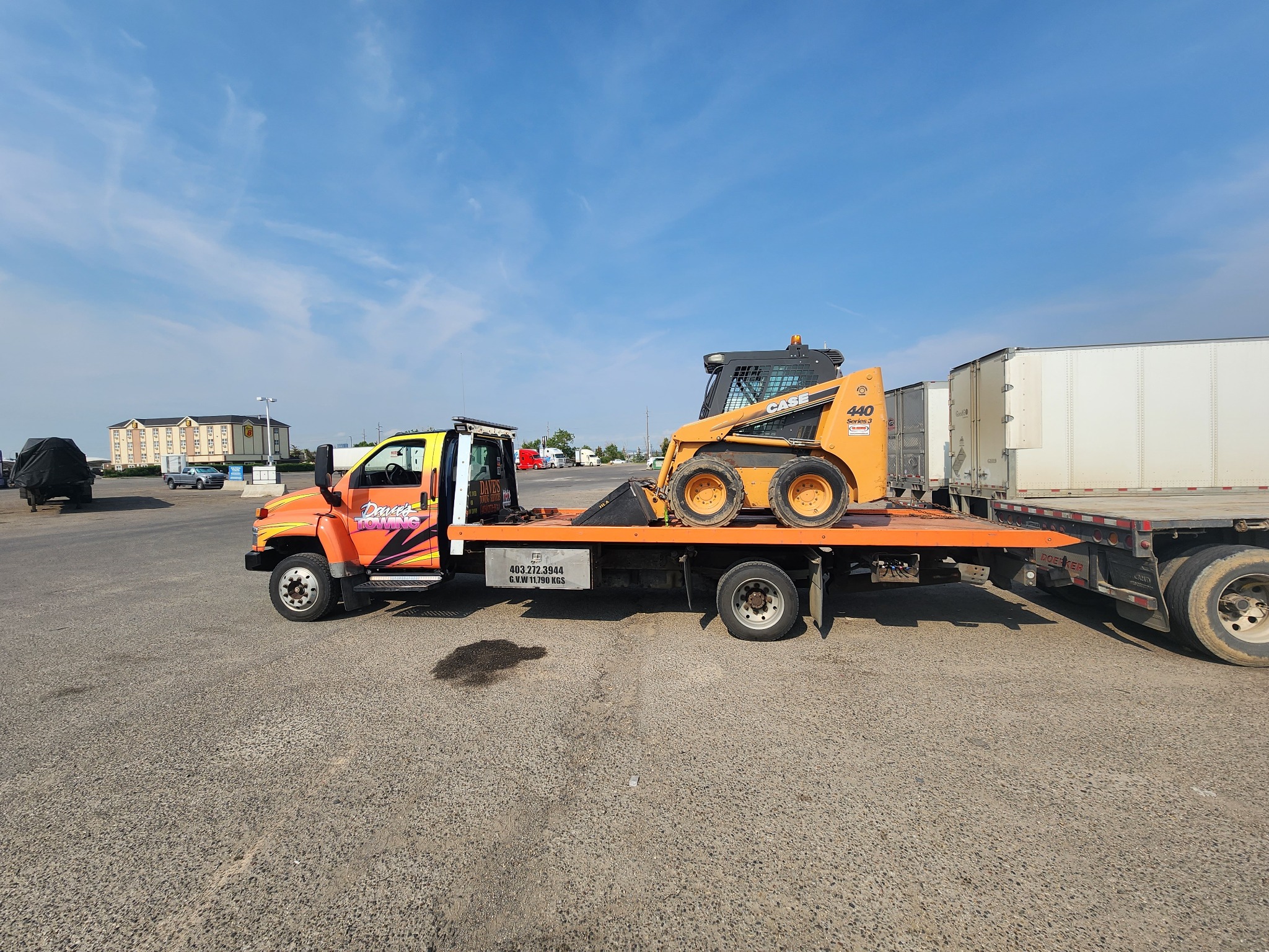 Flatbed tow truck hauling equipment in Calgary